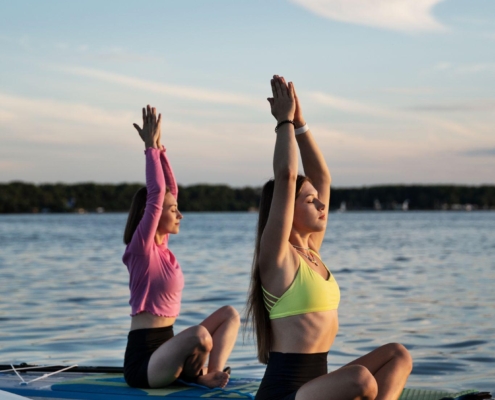 Personas practicando yoga paddle surf al atardecer en Palm-Mar, Tenerife